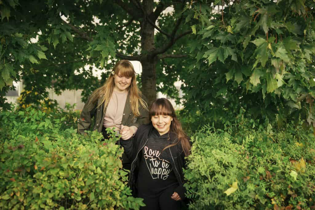 Två flickor skrattar i naturen.