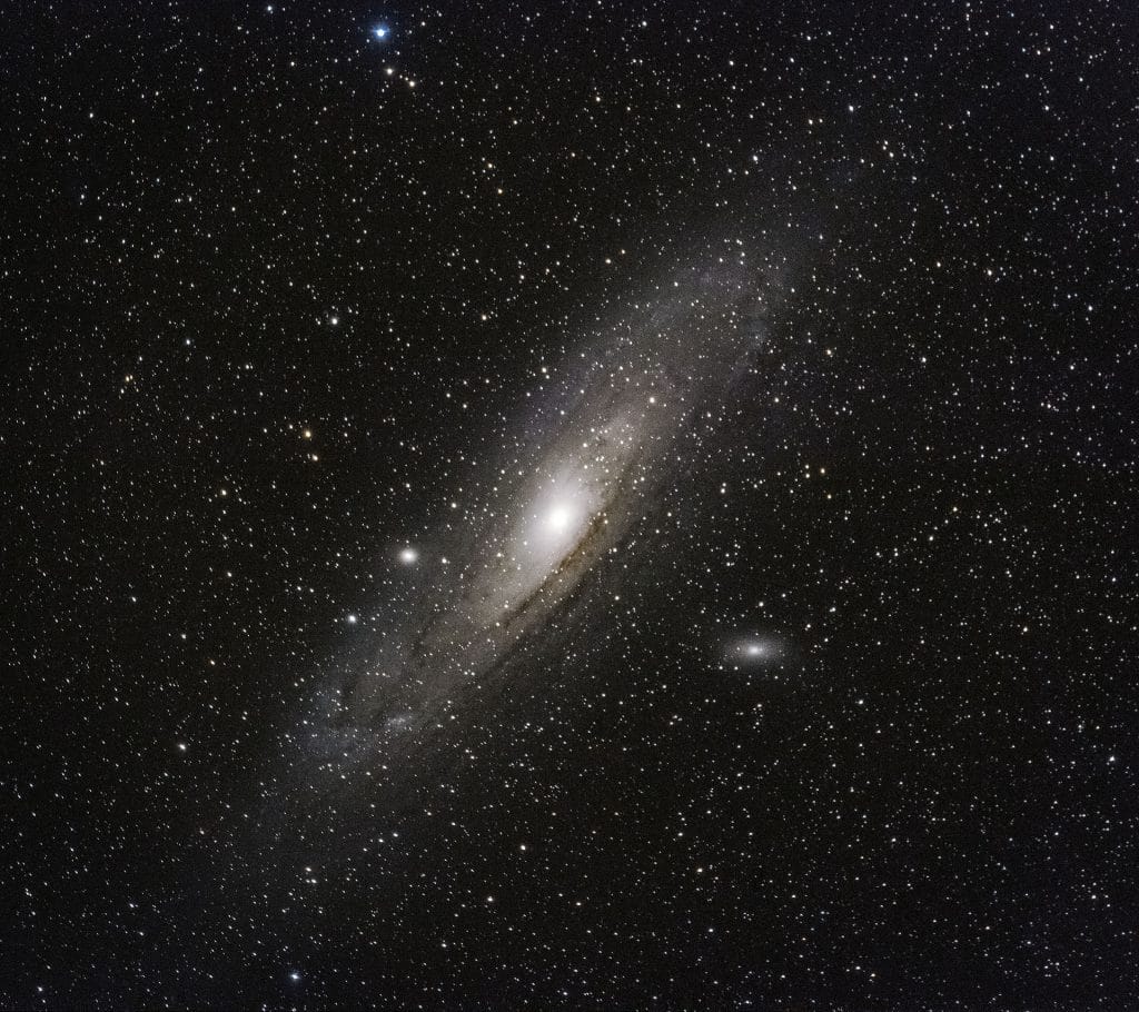 The Andromeda spiral galaxy looks like a hazy disc in the night sky.