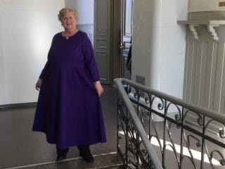 Nainen yllään violetti pitkä mekko.