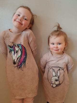 kaksi tyttöjen trikoomekkoa eläinaiheisilla painetuilla kuvilla.