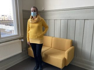 Nainen yllään trikoohuppari keltainen.