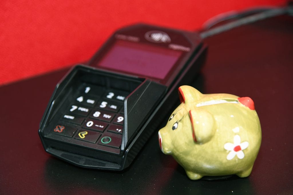 A payment terminal and a yellow piggy bank.