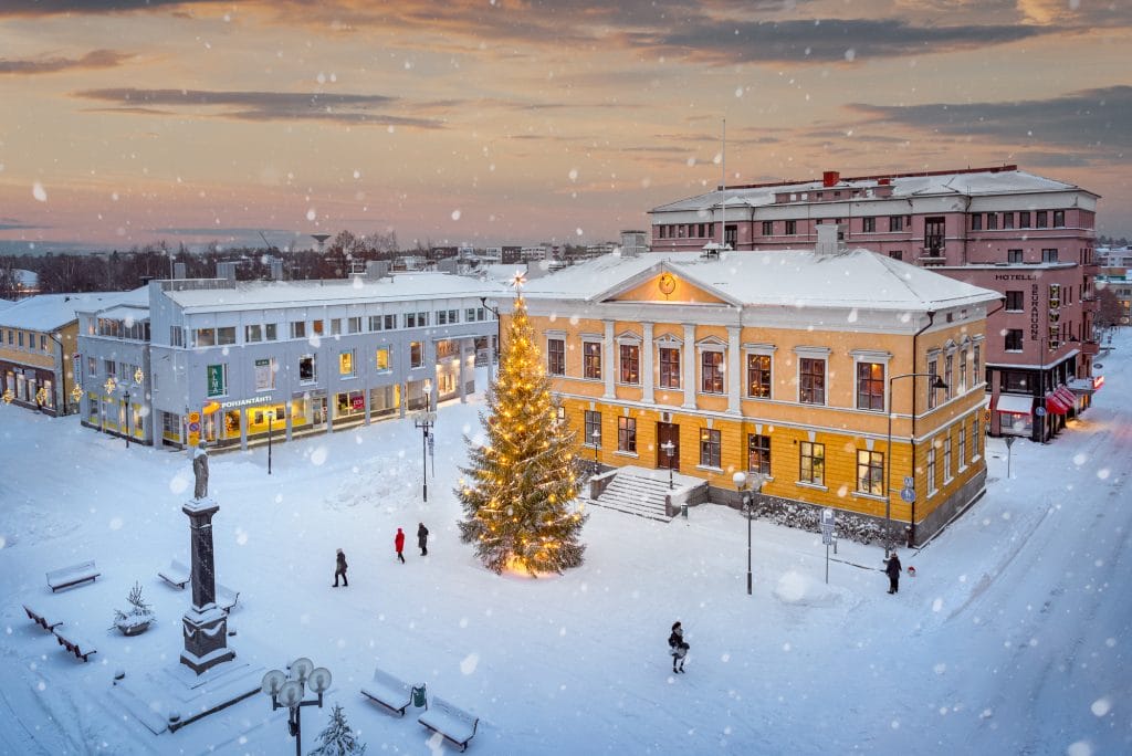 Raati huone ja joulukuusi lumisella Mannerheiminaukiolla.